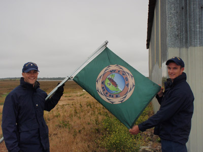Taken by Petty Officer 1st Class Karen Sinkey. Petty Officer 3rd Class Blaine Meserve-Nibley and Chief Petty Officer Cody Staneart prepare to raise the Wiyot Tribe's flag before operations begin at Indian Island in Eureka, CA. As is custom with raising and lowering the National Ensign at sunrise and sunset, Coast Guard responders maintained the same courtesies with the Wiyot flag on the sacred burial grounds.